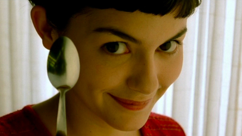Audrey Tautou as Amelie, holding spoon and smiling