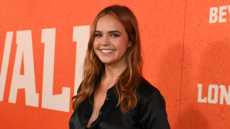 Bailee Madison posing in front of an orange background