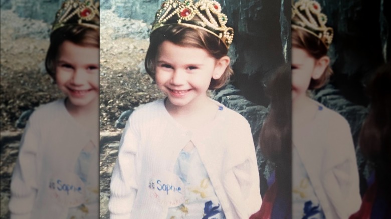 A young Sophie Flay smiles and wears a bejeweled tiara