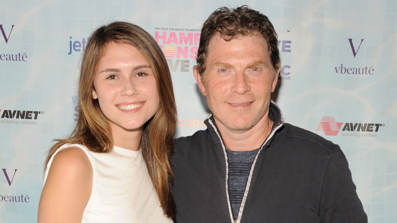 Sophie and Bobby Flay smiling on step-and-repeat