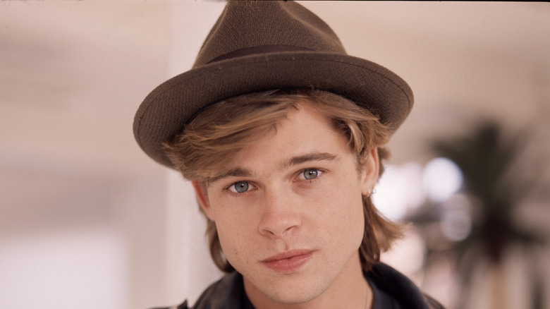 A young Brad Pitt wearing hat