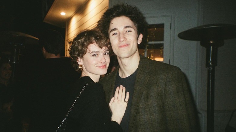 Holden Fraser poses smiling with his girlfriend outside at night