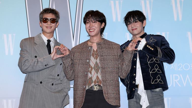 R.M., J-Hope, and V (Kim Tae-hyung) smiling at an event in 2025.