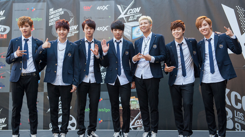 BTS waving and smiling at a convention.