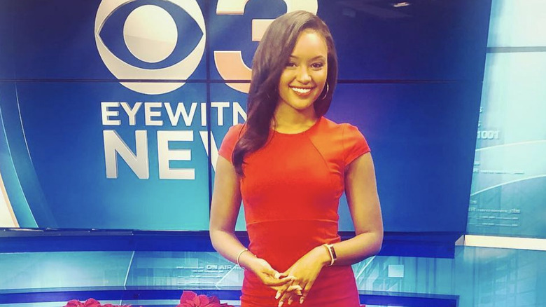 Rahel Solomon smiles in a red dress at a local news station