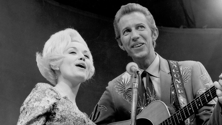 Dolly Parton and Porter Wagoner singing into mic in the 1960s