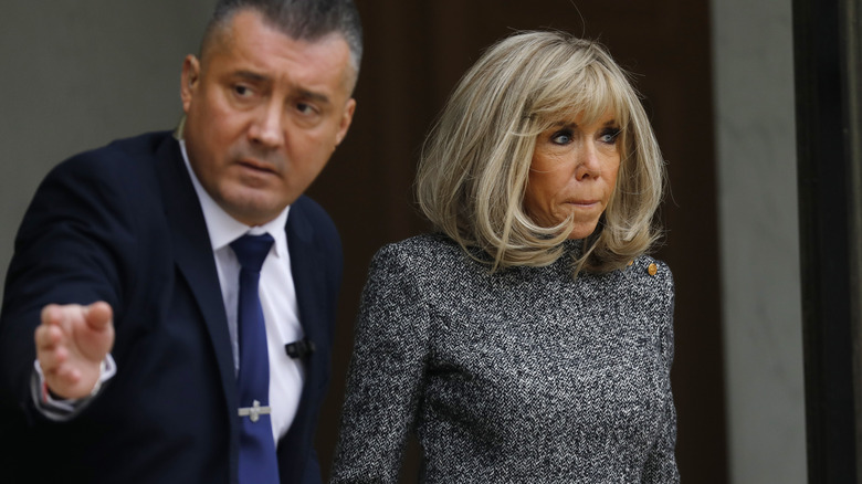 Brigitte Macron being guided by security