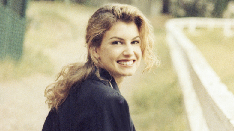 Faith Hill smiling over her shoulder as she walks outside in the country