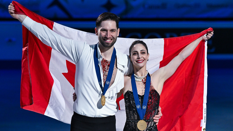 Deanna Stellato-Dudek and Maxime Deschamps waving the Canadian flag