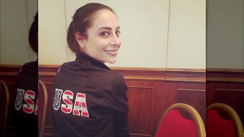 Deanna Stellato-Dudek pictured from the back wearing a USA jacket and turning her head to look at the camera