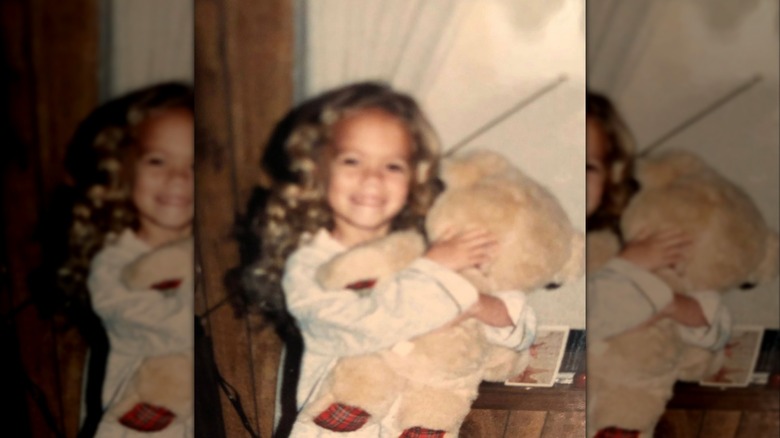 A young Bethany Joy Lenz holding a teddy bear