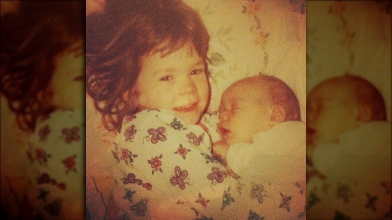 Harry Styles as a baby with his older sister