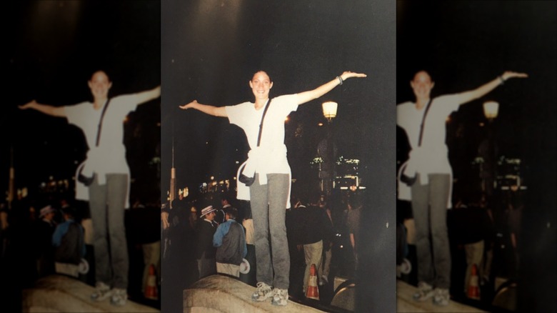 A photo of a young Jennifer Carpenter on a Parisian street with her arms outstretched