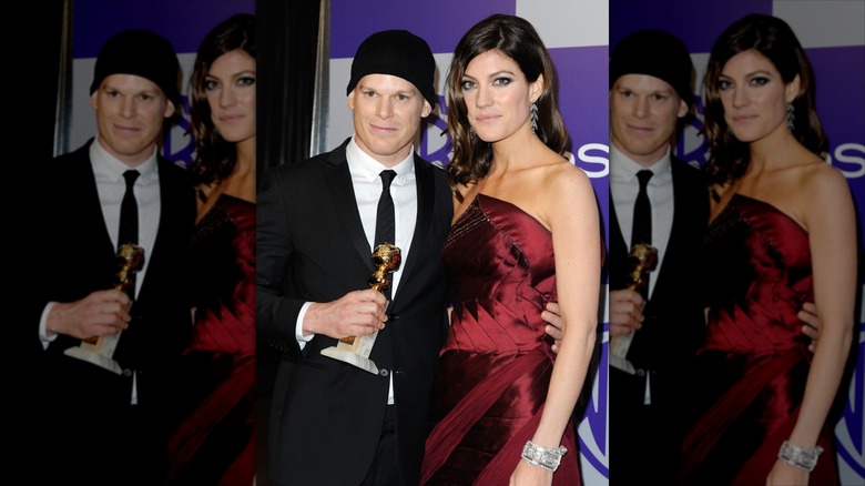 Michael C. Hall wearing a hat, holding his Golden Globe with his arm around Jennifer Carpenter