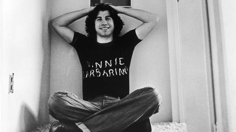 John Travolta in the '70s wearing a shirt that says "Vinnie Barbarino"