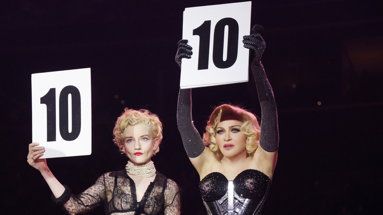 Julia Garner and Madonna holding up number cards during The Celebration Tour