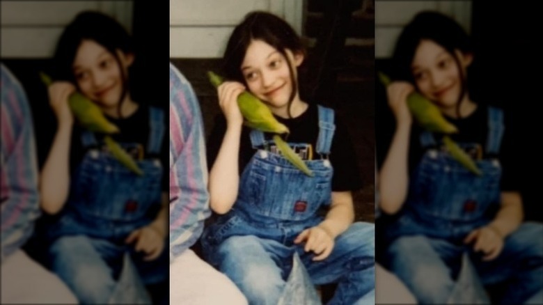 Young Kat Dennings with corn