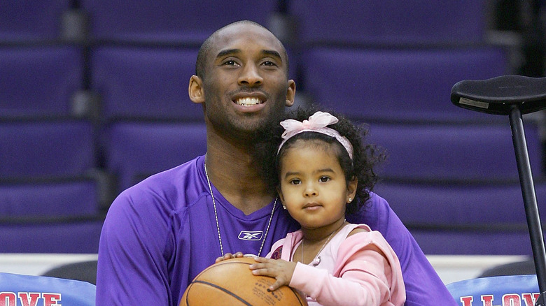 Natalia Bryant as a baby sitting with Kobe Bryant 