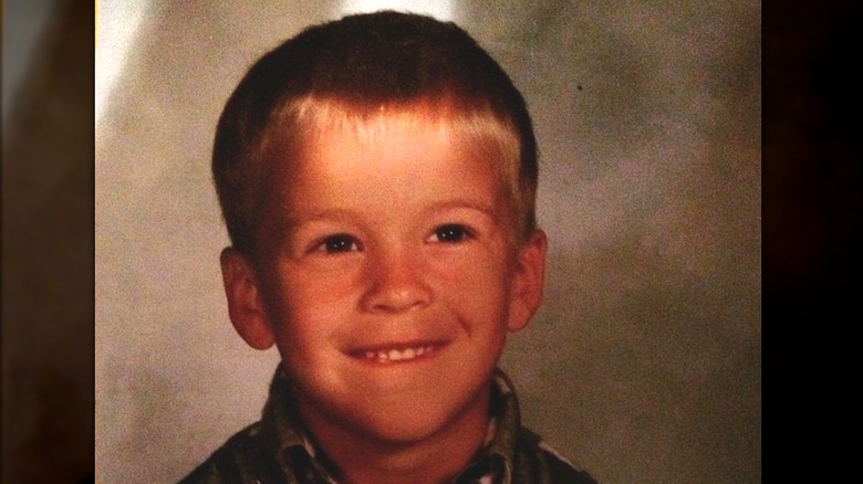 Mitchell Slaggert as a young child with blond hair smiling in a plaid shirt