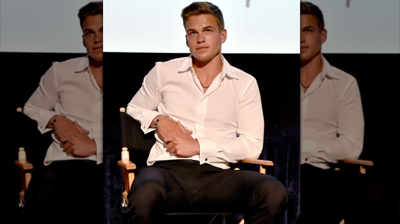 Mitchell Slaggert sitting in chair in white shirt and black pants