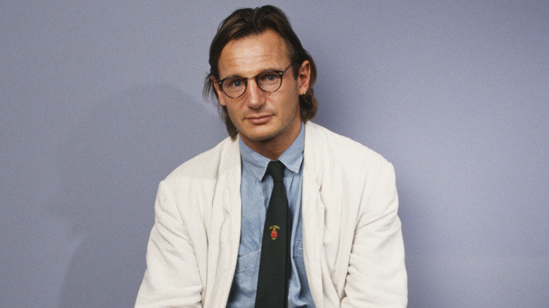 Liam Neeson with a purple backdrop