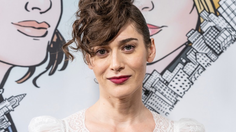 Lizzy Caplan smirking