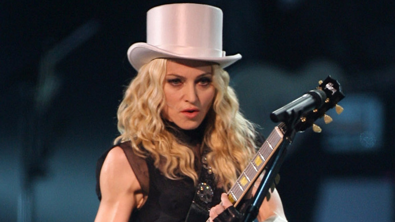 Madonna singing on stage with a guitar