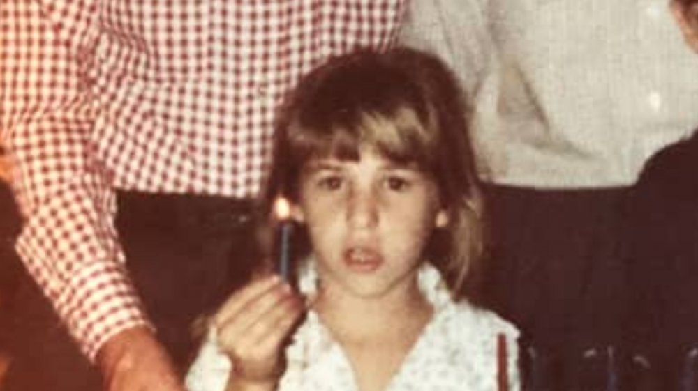 Mayim Bialik as a young girl holding a candle