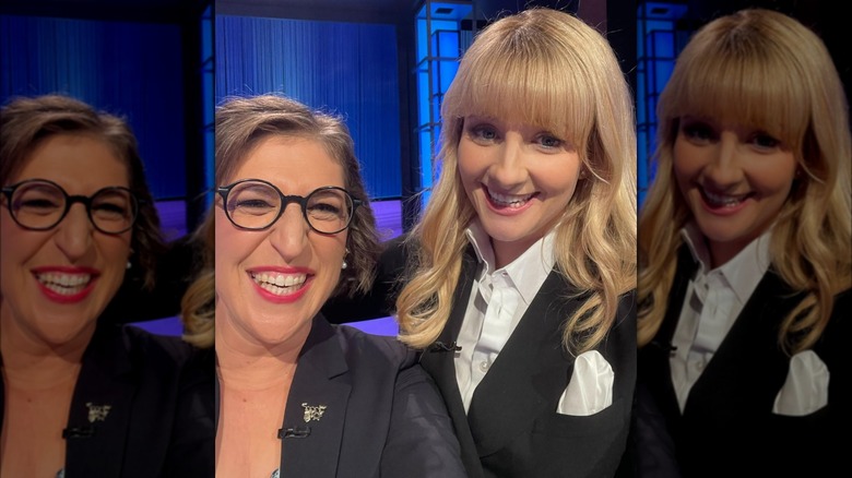 Mayim Bialik and Melissa Rauch wearing dark blazers and taking a selfie on the "Jeopardy!" set