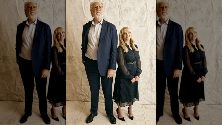 Melissa Rauch wearing a black dress, posing next to John Larroquette, and gazing up at him