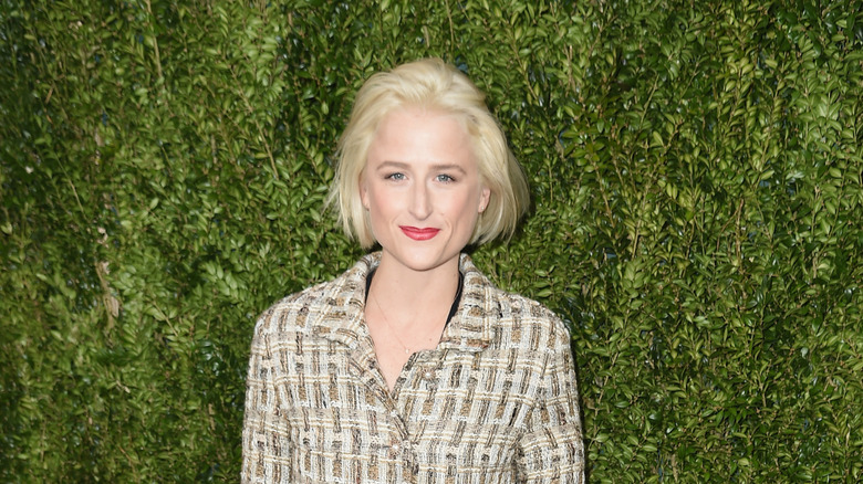 Mamie Gummer posing in front of greenery