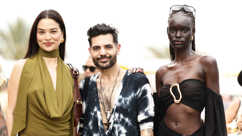Michael Costello posing with models at a Revolve event in 2025