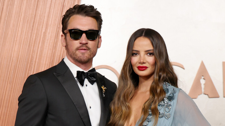 Miles Teller and Keleigh Sperry posing on the 2025 Oscars step-and-repeat