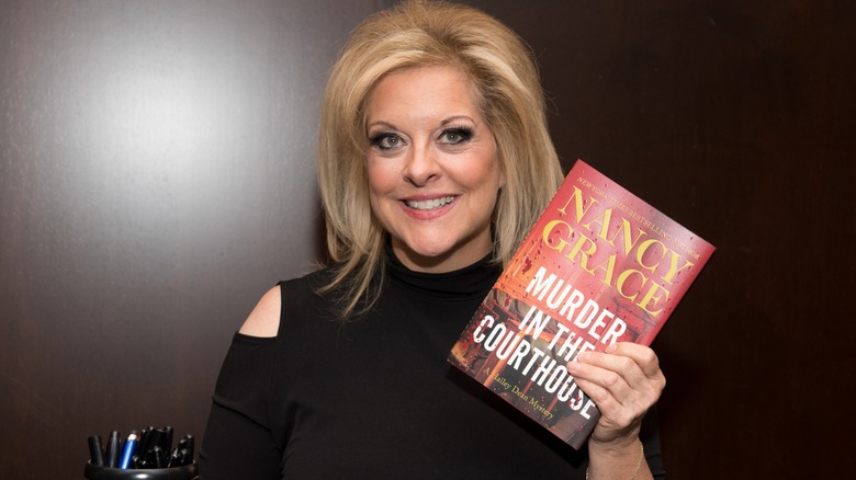 Nancy Grace holding a copy of "Murder in the Courthouse"