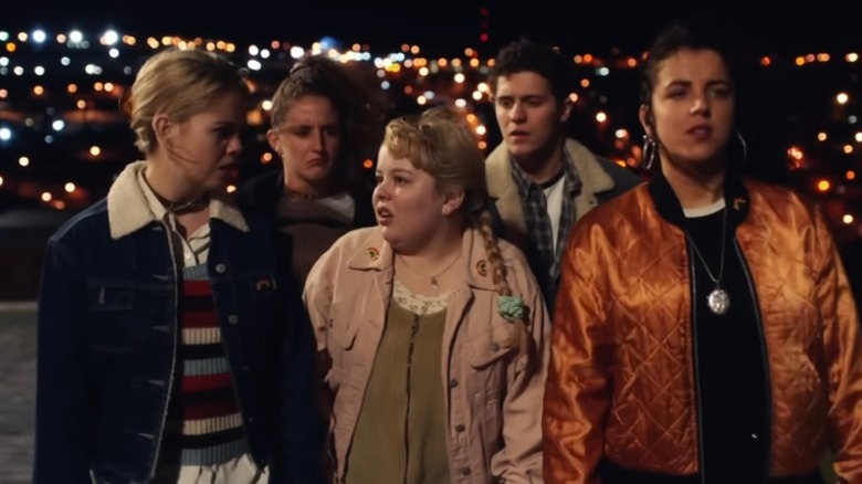 Cast of "Derry Girls" in a scene walking outside at night