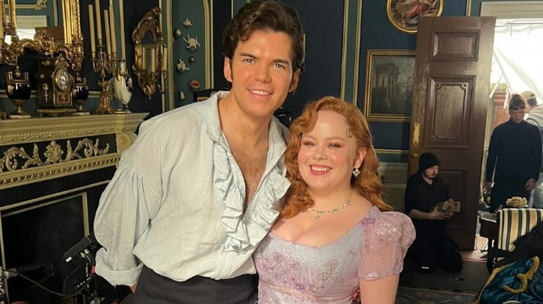 Nicola Coughlan and Luke Newton posing in costume on set of "Bridgerton"