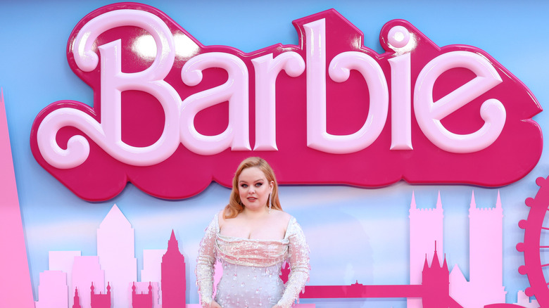 Nicola Coughlan in pink beaded dress standing in front of Barbie sign