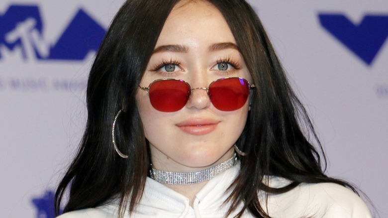 Noah Cyrus wearing red sunglasses 