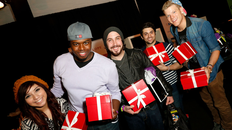 Original Pentatonix group members posing for photo while holding Christmas gifts