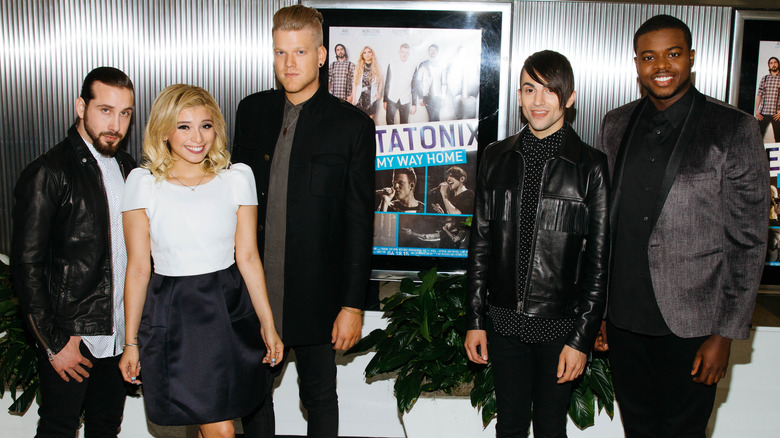 The members of Pentatonix posing in front of the poster at the premiere of "Pentatonix: On My Way Home"