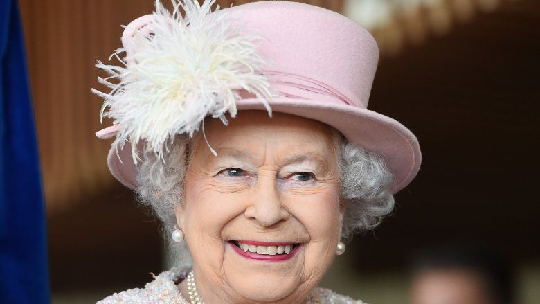 Queen Elizabeth II wearing a pink hat with feathers