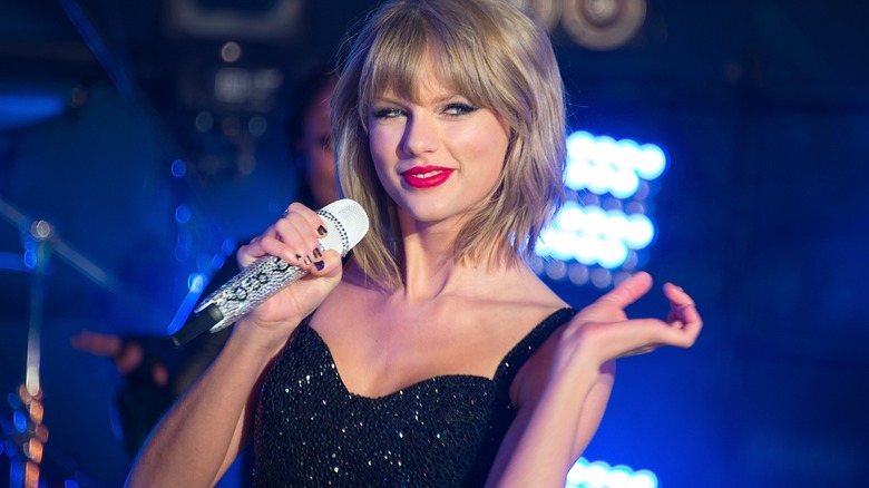 Taylor Swift smiling holding microphone