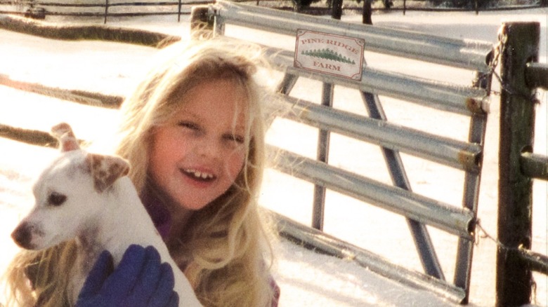 Child Taylor Swift holding a dog in the snow
