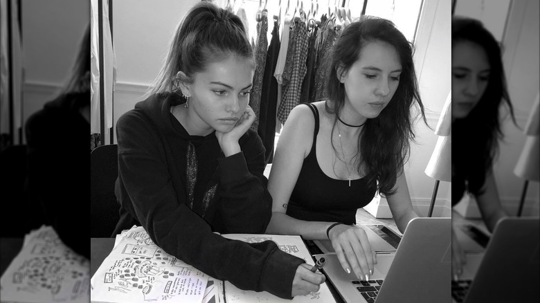 Monochrome shot of Thylane Blondeau and her assistant working on her Heaven May Clothing brand in 2018