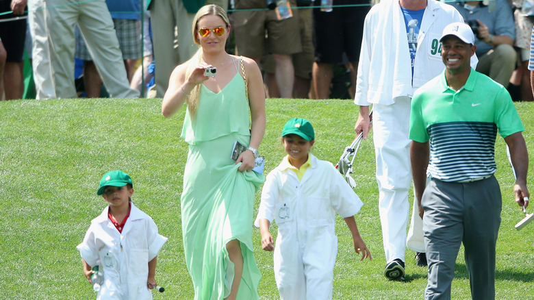 Tiger Woods walks with his two kids and his girlfriend on a golf course when the kids were young