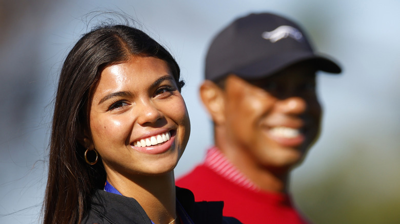 Sam Woods smiles outside next to Tiger Woods at a golf tournament