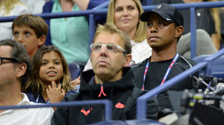 A young Sam and Tiger Woods in the audience of a sports game