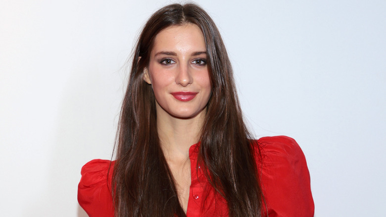 Tim McGraw and Faith Hill's daughter Audrey McGraw smiling in a red shirt with her long hair down