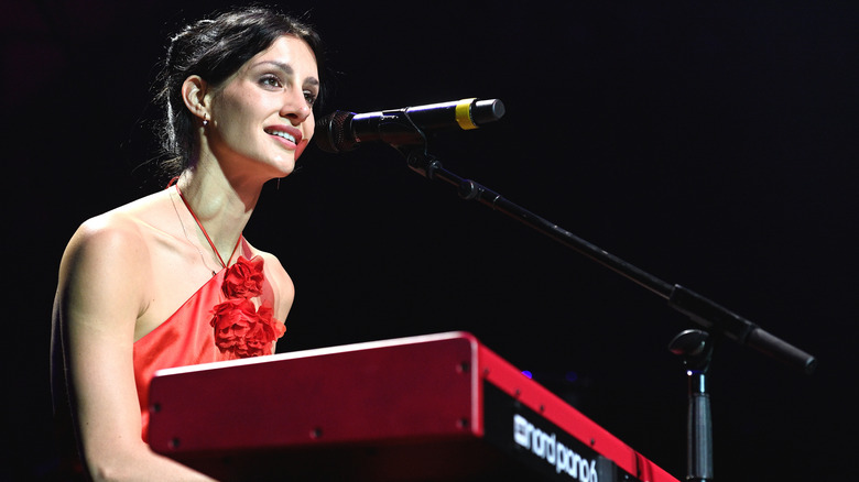 Tim McGraw's daughter Audrey sings and plays piano onstage in a red dress