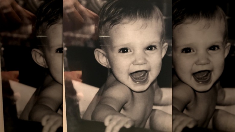 Tim McGraw's daughter Audrey smiling as a baby in a tub in a black and white photo
